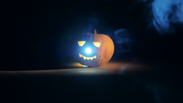 Radiating jack-o-lantern is standing in the clouds of smoke — Stock Video