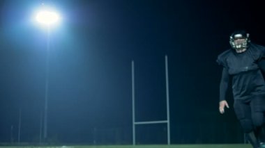 Amerikalı futbolcu uçan topu yakalar ve bir kameraya benziyor. 4k.
