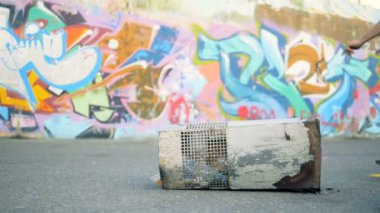 Genç aktif skare yavaş çekimde bir kaykay üzerinde atlar.