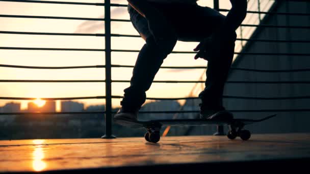 Skateboarder saltando sobre un fondo al atardecer, cámara lenta . — Vídeos de Stock