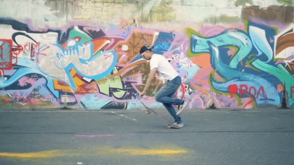 Skater saute sur un fond de mur coloré, au ralenti . — Video