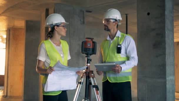 A male and a female engineers in the middle of a discussion in the building house — Stock Video