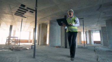 Üzerinden yürüyen bir erkek mühendis İnşaat sürüyor bina