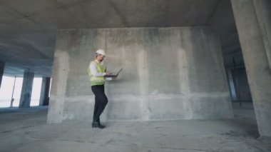 Erkek bina müfettişi hızlı inşaat site üzerinden yürüyor