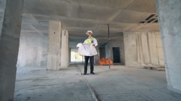 360 μοίρες πλάνα από ένα αρσενικό μηχανικός που στέκεται στη μέση του και ενός κτιρίου χώρου — Αρχείο Βίντεο