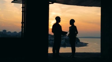 İnşaat bina iç altında bir tartışma içinde sahip iki arkadan aydınlatmalı müfettişleri ile
