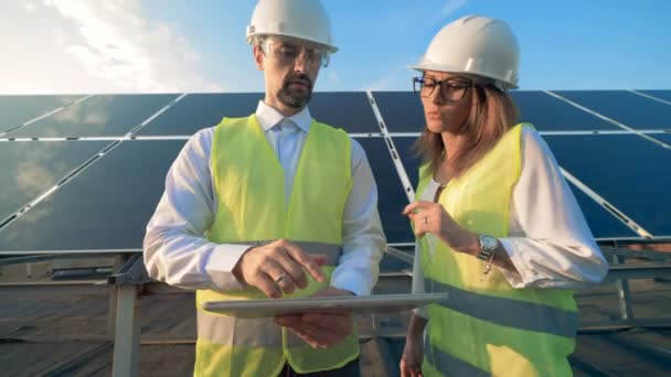 Solar engineers work on a rooftop, close up. — Stock Video