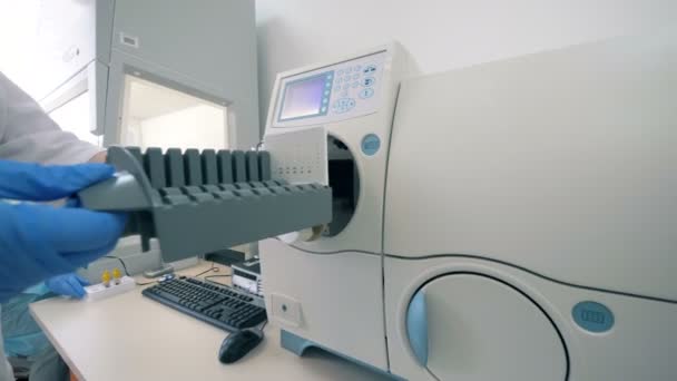 Trabalhador de laboratório carrega a máquina em uma sala de laboratório . — Vídeo de Stock