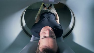 Arkadan görünüm bir tomografik yatakta yatan bir insan.