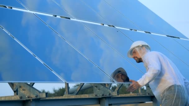 Um trabalhador limpando baterias solares. Conceito de indústria inovadora . — Vídeo de Stock