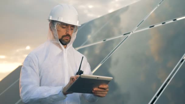 Un hombre de uniforme trabaja con una tableta, de cerca . — Vídeos de Stock