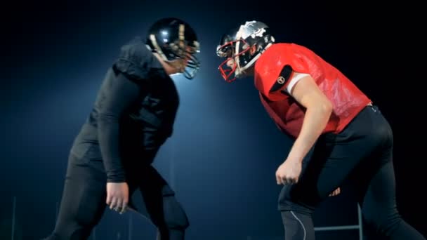 男性は頭に、スタジアムでアメリカン フットボールをプレーする準備ができて立っています。4 k — ストック動画