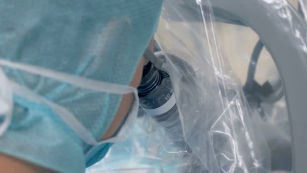 Medisch-werker ziet er in een Microscoop tijdens chirurgie. 4k — Stockvideo