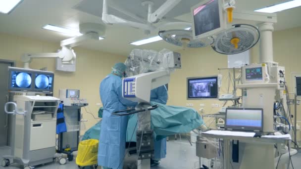 Yenilikçi tıp kavramı. Bir cerrah bir klinikte ameliyat sırasında modern mikroskop ve cerrahi robot kullanır. — Stok video