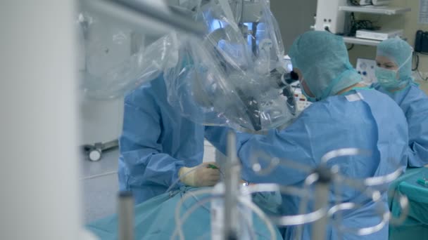 Многие врачи в операционной. Врачи и медсестры проводят операцию в помещении . — стоковое видео
