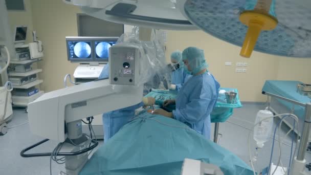 Trabajadores médicos que realizan una cirugía utilizando un robot médico moderno . — Vídeos de Stock