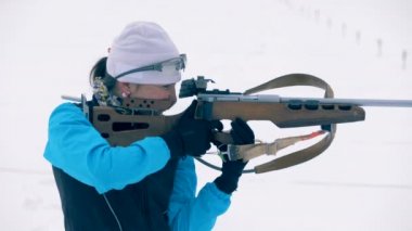 Kayakçı standları bir tüfekle, yan görünüm.