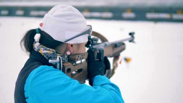 Sportschütze nimmt Gewehr weg, Rückansicht. — Stockvideo