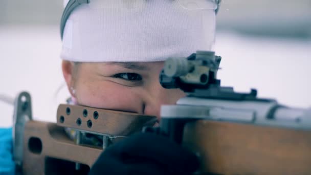 Одна женщина стоит и целится из спортивной винтовки во время соревнований. 4K — стоковое видео