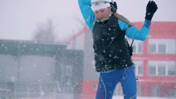 Sportswoman compete em uma corrida de biatlo, preparando-se para atirar. 4K — Vídeo de Stock