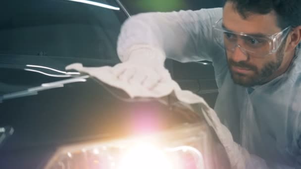 Serviceman torkar en bil, närbild. Person använder en trasa för att torka en bil efter polering. — Stockvideo