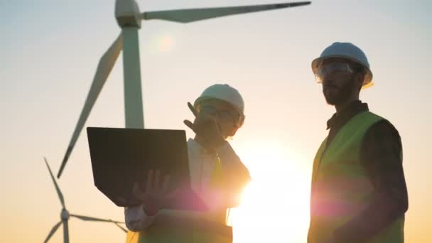 Los trabajadores hablan sobre un fondo atardecer, de cerca . — Vídeos de Stock