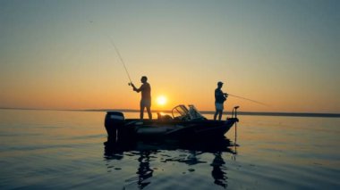 Balıkçılar günbatımı bir arka planda yan görünüm.