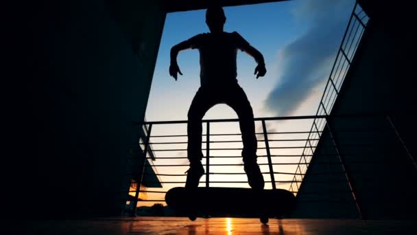 一个人跳上滑板, 站在它一边做把戏。慢动作. — 图库视频影像