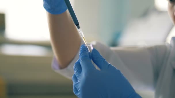 Verpleegkundige maakt gebruik van een pipet, stromende vloeistof in een laboratorium-kamer. — Stockvideo