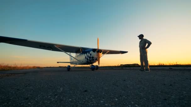 Vlucht ingenieur kijkt een aiplane in de open lucht. — Stockvideo