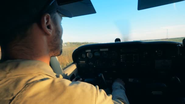 Acercamiento de un aviador macho pilotando un avión mientras está sentado en una cabina — Vídeos de Stock