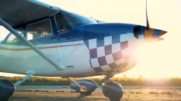 Μπλε και άσπρο διπλάνο, αεροπλάνο, αεροπλάνο, αεριωθούμενο με έλικα εργασίας στις ακτίνες του ήλιου — Αρχείο Βίντεο