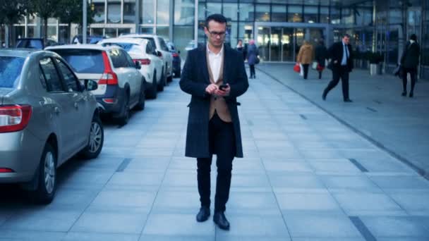 Cluster de negócios com um gerente de escritório com um smartphone dando um passeio ao longo dele. Dragão épico vermelho 6K tiro . — Vídeo de Stock