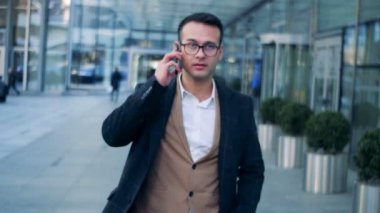 Telefon görüşmesi kentsel Caddesi'nde, şehir merkezine yürüyüş bir işadamı. Kırmızı epik sinema kamera görüntüleri.