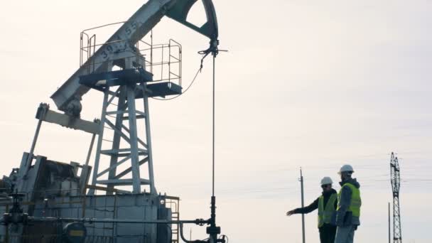 Petrol derricks çalışmalarını kontrol erkekler. Petrol üretim sanayi kavramı. — Stok video