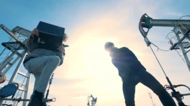 Dans, eğlenceli bir petrol sahası üzerinde sahip iki mutlu mühendis.