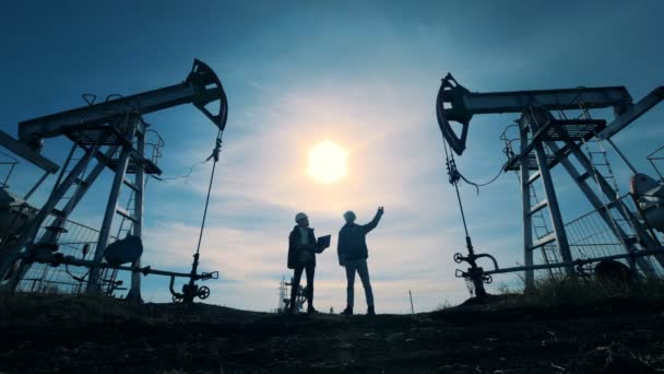Ingenjörer titta på olja pumpar arbetar. Oljeriggar pumpning. — Stockvideo
