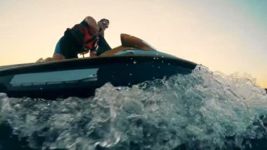 Bir profesyonel ile günbatımı waterscape bir yelkenlilisanslı, waverunner binme