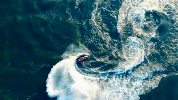 Jetskier draait op zijn waterbike, waverunner over het water in een bovenaanzicht. — Stockvideo