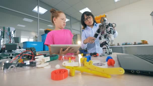 Kinderen proberen te maken van een robot op een tafel, met behulp van tools. 4k. — Stockvideo