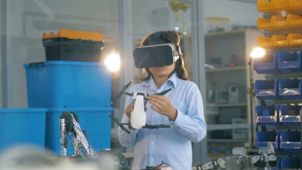 Criança em uma sala de laboratório segura um brinquedo branco enquanto usa óculos VR . — Vídeo de Stock