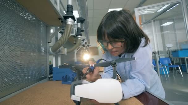 Un bambino che fissa un drone in laboratorio, da vicino . — Video Stock