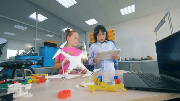 Young kids repair a drone together, close up. — Stock Video