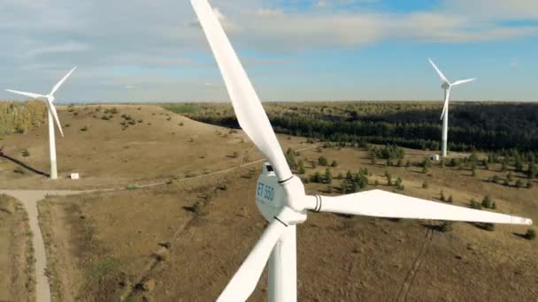 Windgenerators werken op de achtergrond van een bos. Luchtfoto. — Stockvideo