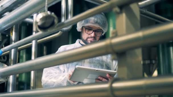 Factory worker in uniform with tablet, close up. — Stock Video