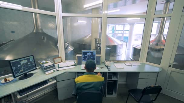 Man aan het werk met de computer in een brouwerij. — Stockvideo