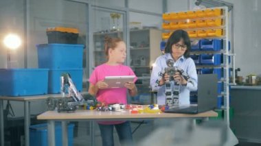 Genç çocuklar birlikte çalışan bir laboratuvar odasında. Okul çocukları oyuncak bir robot inşa etmek Labaratuar donanımları kullanın.