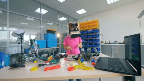 Девушка стоит рядом со столом с игрушками, в 360 VR очках. 4K — стоковое видео
