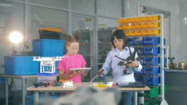 Crianças trabalhando em uma sala de laboratório com VANT, drones, helicópteros . — Vídeo de Stock