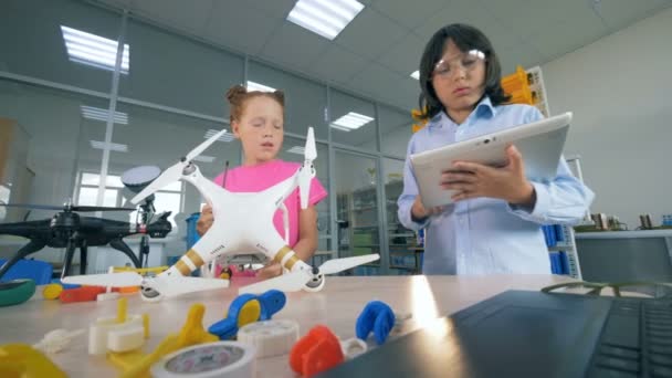 Los niños que trabajan inspeccionan un dron, se acercan . — Vídeo de stock